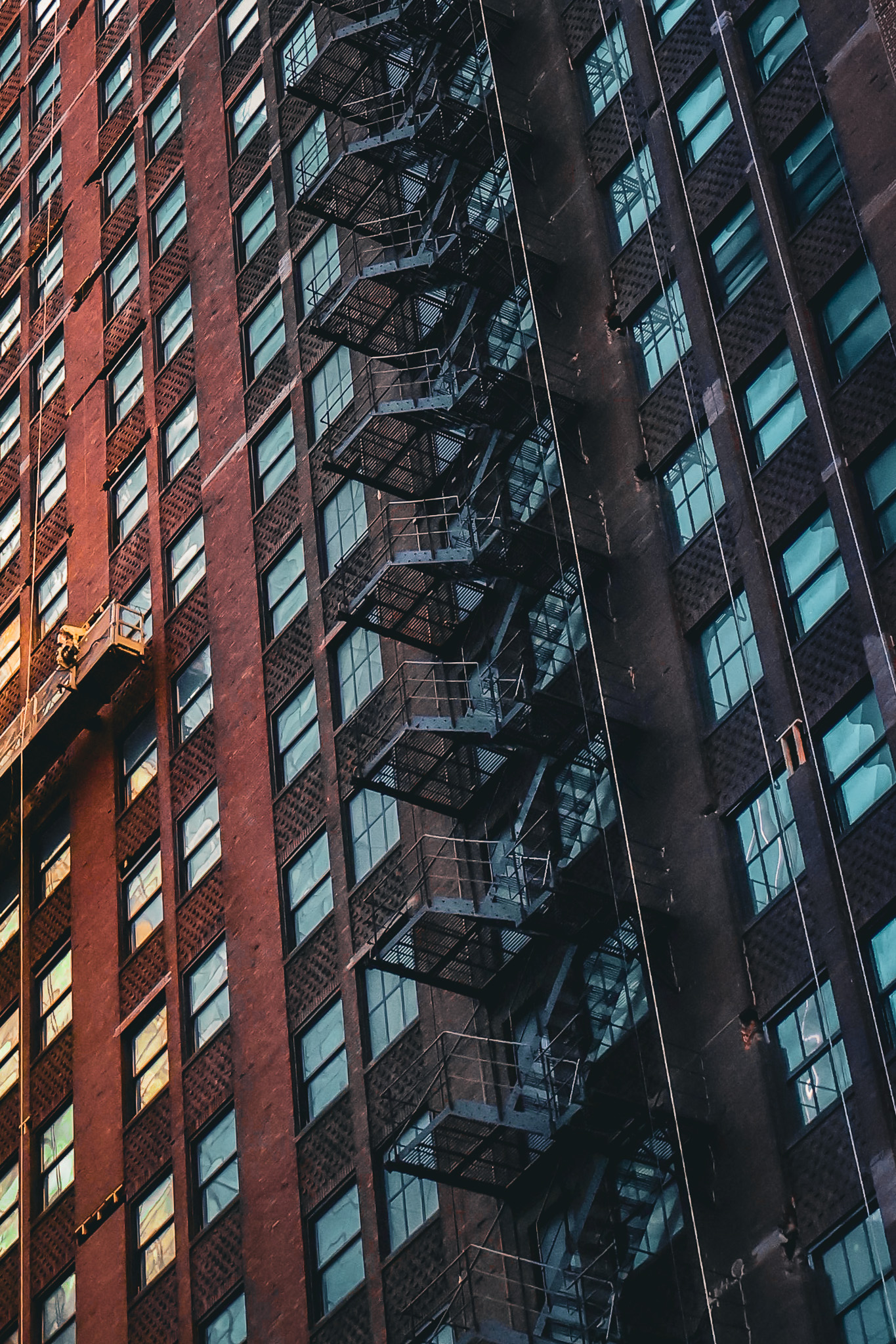 Close view of brick buildings and fire escapes in warm evening light.